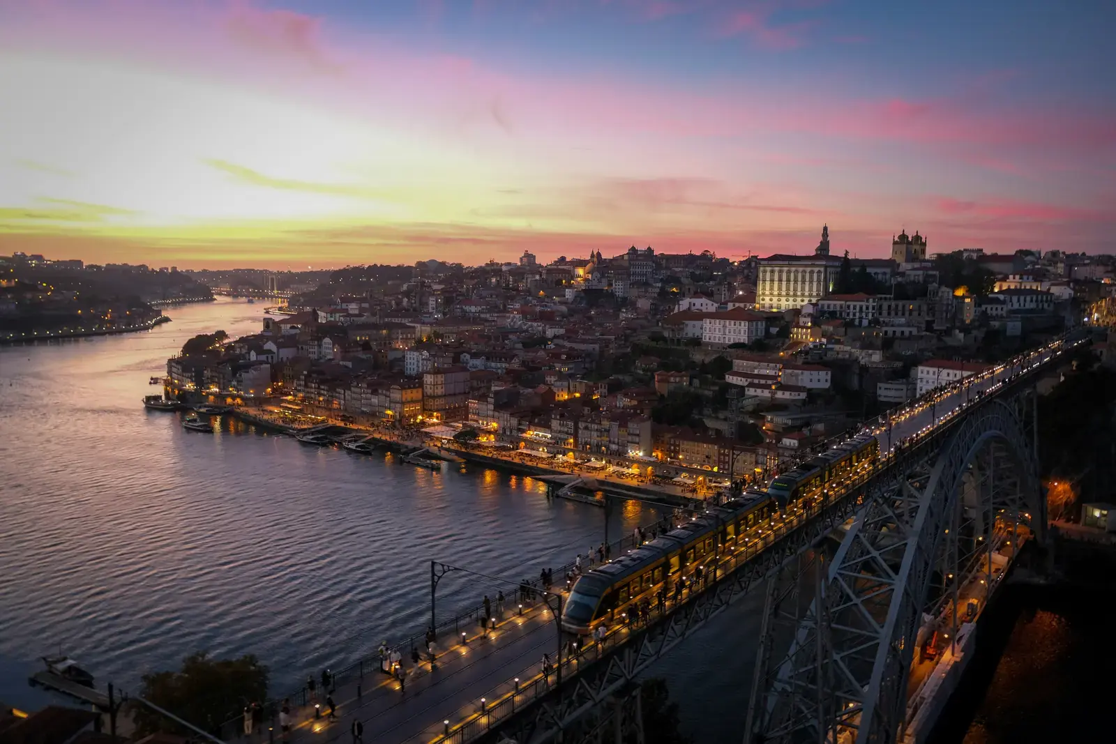 The Douro river and Dom Luís I Bridge glowing over Porto at blue hour.